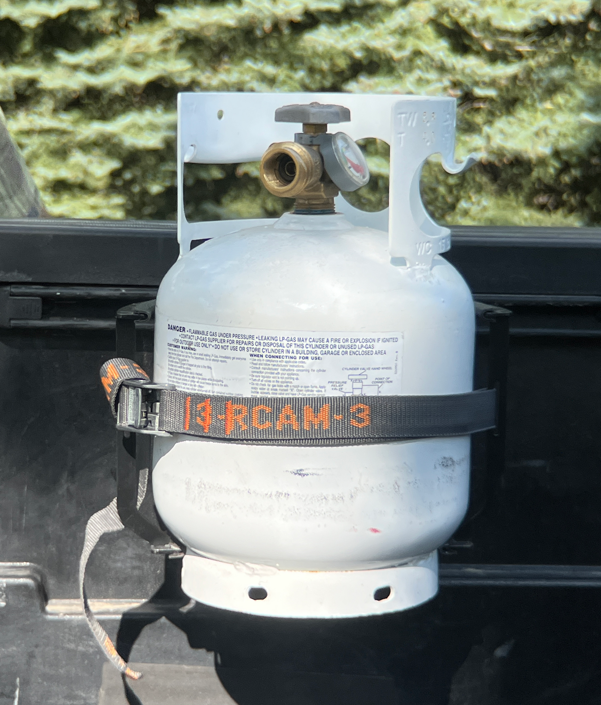Installed propane tank into bracket with cam strap.